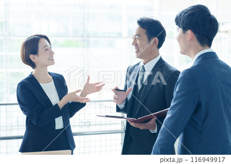 オフィスで立ち話をするビジネスパーソン オフィスで立ち話をするビジネスパーソン 116949917