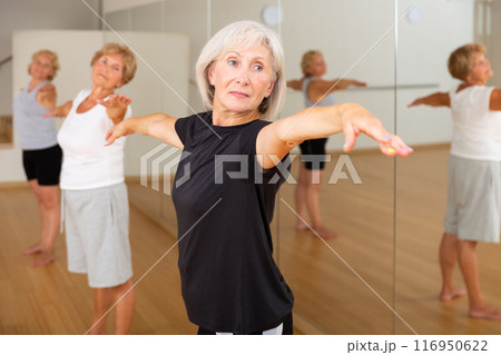Aged women performing ballet dance in fitness room 116950622