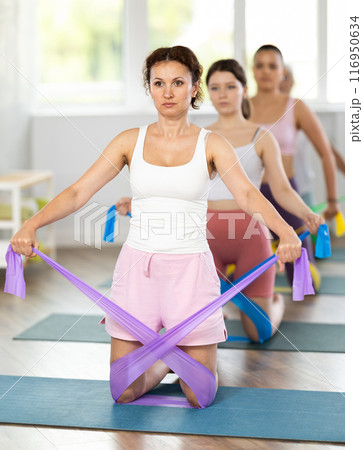 Adult woman exercising with pilates band Adult woman exercising with pilates band 116950634