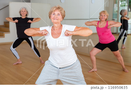Active elderly lady learning modern dynamic dances in choreography class 116950635