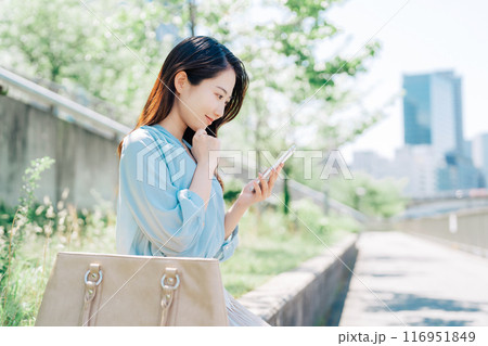 屋外でスマホを見る女性 116951849