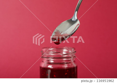 Jar with fig jam and spoon on pink background, close up Jar with fig jam and spoon on pink background, close up 116951962