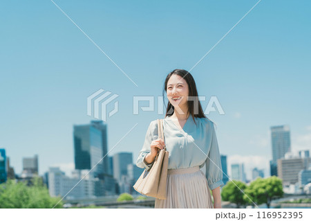 青空とビル群を背景にしたビジネスウーマン 青空とビル群を背景にしたビジネスウーマン 116952395