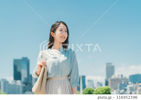 青空とビル群を背景にしたビジネスウーマン 青空とビル群を背景にしたビジネスウーマン 116952396