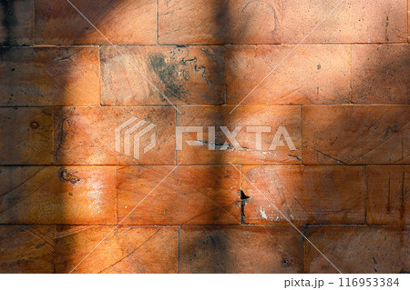 A brick wall with a shadow cast on it A brick wall with a shadow cast on it 116953384