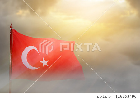 A Turkey flag with a star and crescent moon flying in the sky A Turkey flag with a star and crescent moon flying in the sky 116953496