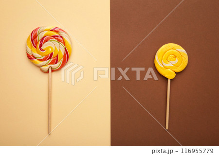 Two colorful sweet lollipops for children on brown 116955779
