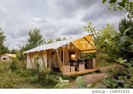 Cozy open glamping tent with light inside. Camping tent for outdoor summer holiday and vacation 116955832