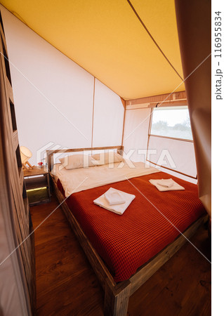 Interior of cozy open glamping tent. Camping tent for outdoor summer holiday and vacation 116955834