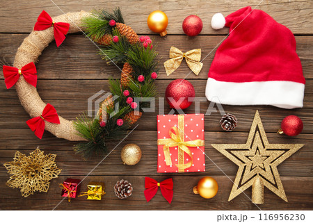 Christmas decorations with Santa hat and wreath on grey background. 116956230
