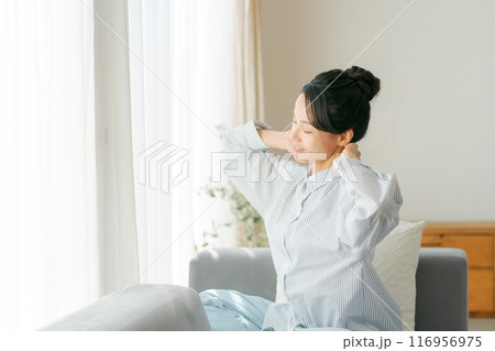 リビングでストレッチをする30代女性 116956975