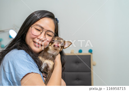 A lovely moment of a girl hugs her dog, Chi Hua Hua. The dog feels her love then she split her tounge out. A lovely moment of a girl hugs her dog, Chi Hua Hua. The dog feels her love then she split her tounge out. 116958715