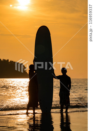 Art Silhouette Smart Asian Couple Man and Woman, a romantic shot with Standed Surboard on beach with sunset behind them. Art Silhouette Smart Asian Couple Man and Woman, a romantic shot with Standed Surboard on beach with sunset behind them. 116959337