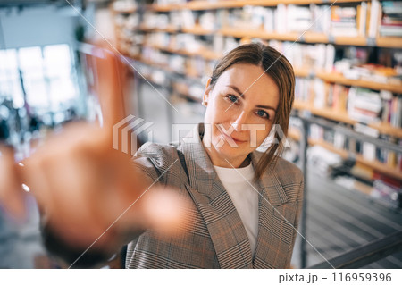 A woman's warm smile in a library setting A woman's warm smile in a library setting 116959396