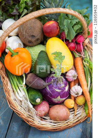 A large wicker basket with various fruits and vegetables 116959432