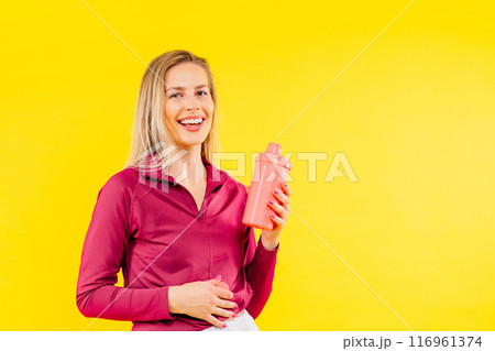 Attractive woman and water bottle for body diet, health and wellness against a studio background. Attractive woman and water bottle for body diet, health and wellness against a studio background. 116961374