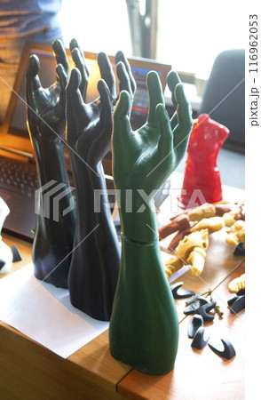 Art Object human hands printed on 3D printer. Model prototype of human hand printed on 3D printer from molten plastic standing on a table. FDM 3D printing technology. New modern additive technologies Art Object human hands printed on 3D printer. Model prototype of human hand printed on 3D printer from molten plastic standing on a table. FDM 3D printing technology. New modern additive technologies 116962053