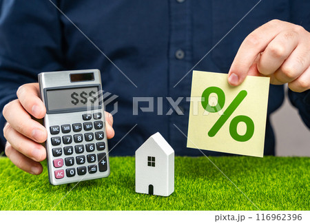 A man uses a calculator to calculate the cost of a house with a mortgage. Mortgage calculator. Study of real estate loan terms, risk assessment. Profitable proposition. 116962396