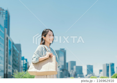 青空とビル群を背景にしたビジネスウーマン 青空とビル群を背景にしたビジネスウーマン 116962910