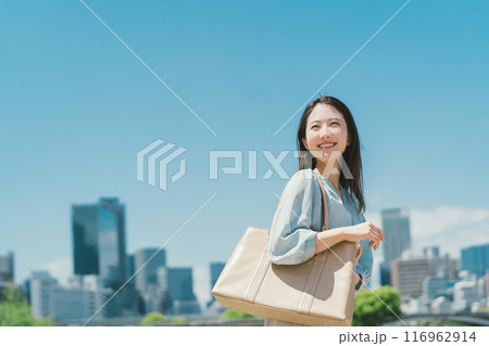 青空とビル群を背景にしたビジネスウーマン 青空とビル群を背景にしたビジネスウーマン 116962914