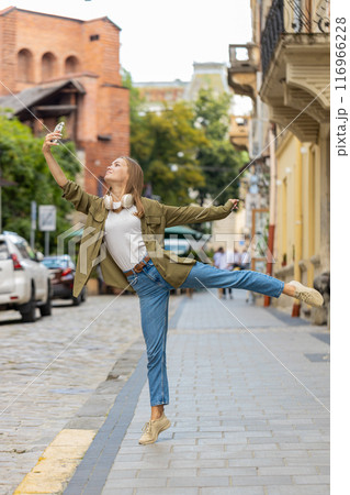 Young tourist woman trying to catch a communication signal and Internet on mobile phone on street 116966228