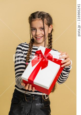 Lovely smiling preteen child girl kid presenting birthday gift box offer wrapped present celebrating Lovely smiling preteen child girl kid presenting birthday gift box offer wrapped present celebrating 116966241