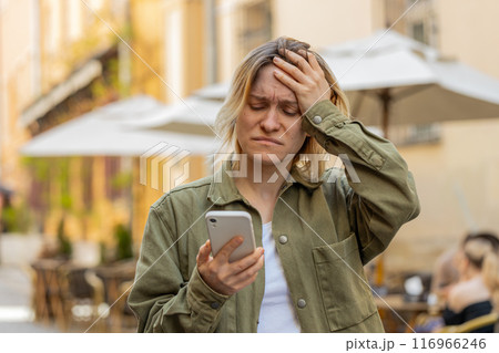 Woman using smartphone typing browsing loses bad news, game lottery casino fail on city street 116966246