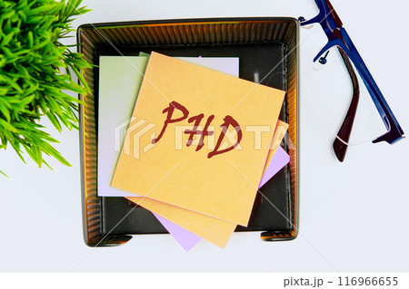 Doctorate of Philosophy concept. PhD on yellow sticker has a top view Doctorate of Philosophy concept. PhD on yellow sticker has a top view 116966655