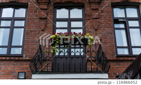 An old, vintage, brick building. Forged steel balcony facing the street 116966852