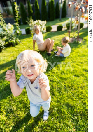 Joyful Mother Engaging With Her Two Sons at a Playground During a Sunny Day Joyful Mother Engaging With Her Two Sons at a Playground During a Sunny Day 116967931