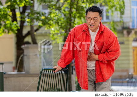 Asian middle-aged man feeling sudden strong abdominal stomach ache gastritis problem diarrhea 116968539