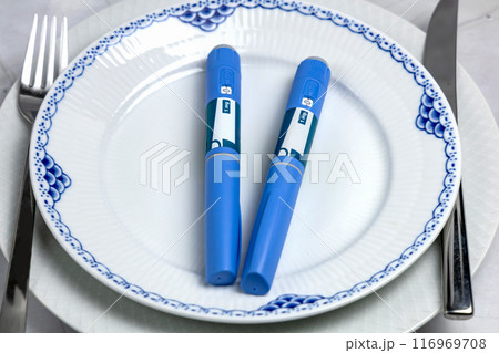Ozempic Insulin injection pen or insulin cartridge pen for diabetics on a white plate. 116969708