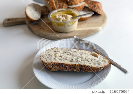 Piece of bread with hummus on a white plate Piece of bread with hummus on a white plate 116970064