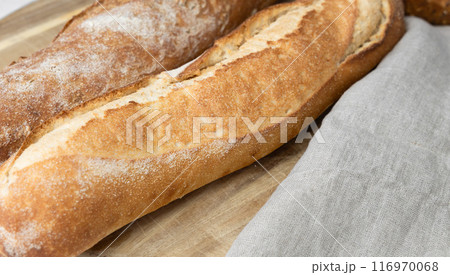 Two fresh baguettes on a cutting board. Two fresh baguettes on a cutting board. 116970068