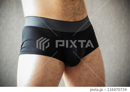 Black male boxer underpants are worn on a young Caucasian man Black male boxer underpants are worn on a young Caucasian man 116970739