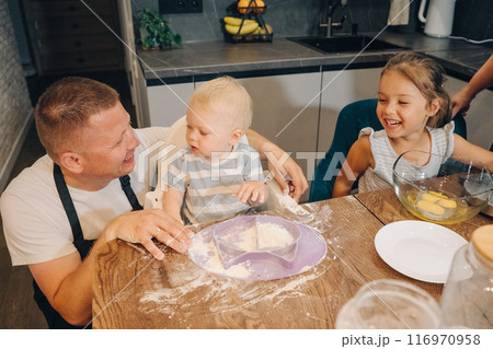 Family Fun Cooking Together with Kids at Home A joyful activity to bond and learn. Happy family enjoys moments of cooking at home. Family Fun Cooking Together with Kids at Home A joyful activity to bond and learn. Happy family enjoys moments of cooking at home. 116970958