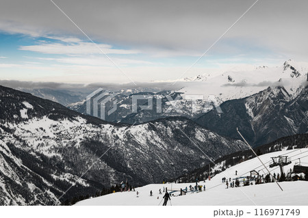 Skiers on a snowy slope in a French Alps ski resort 116971749