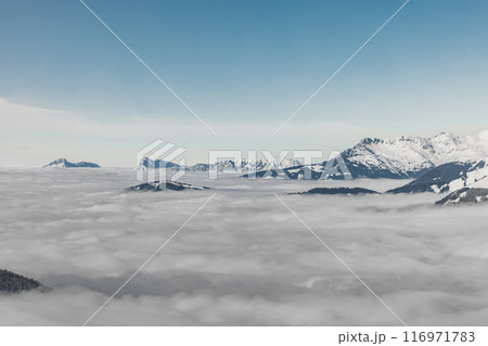 Mountains towering above serene cloud blanket 116971783