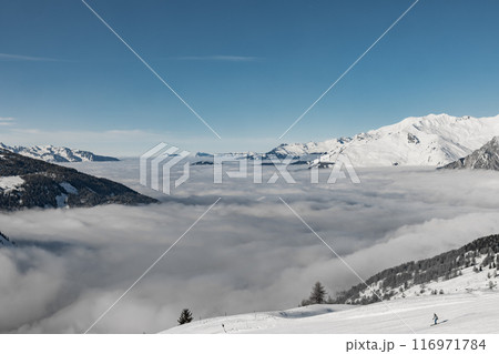 Mountains towering above serene cloud blanket Mountains towering above serene cloud blanket 116971784