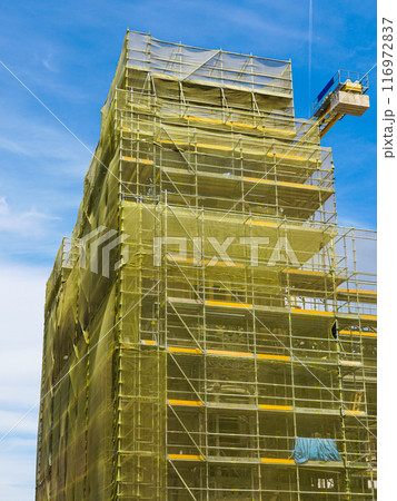 Restoration of the facade of historic house using prefabricated metal scaffolding with a safety net 116972837