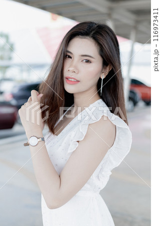 Asian woman in casual work clothes Posing in the parking lot. Asian woman in casual work clothes Posing in the parking lot. 116973411