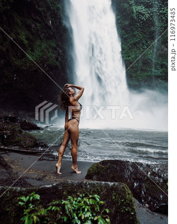 Gorgeous woman in bikini near waterfall in Bali. 116973485
