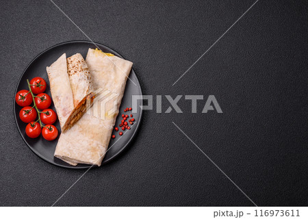 Delicious juicy roll or shawarma with chicken, tomatoes, salad and sauce 116973611