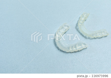 Top View Dirty Teeth Dental Night Guards in Box, White Pink Container. Blue Background. Copy Space For Text. Mockup Clear Retainer. Oral Hygiene, Cleaner. Horizontal Plane. 116973996