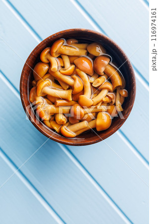 Pickled nameko mushrooms.Traditional japanese mushrooms in bowl on blue table. Top view. 116974161
