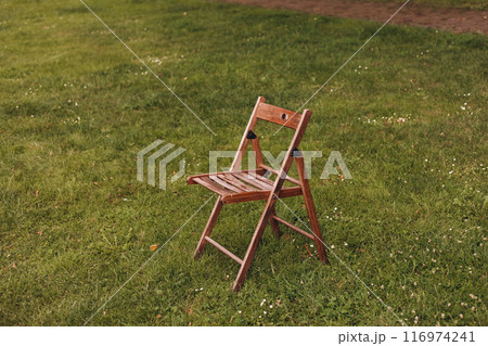 Empty wooden chair on the green lawn. Theme of loneliness. Empty wooden chair on the green lawn. Theme of loneliness. 116974241