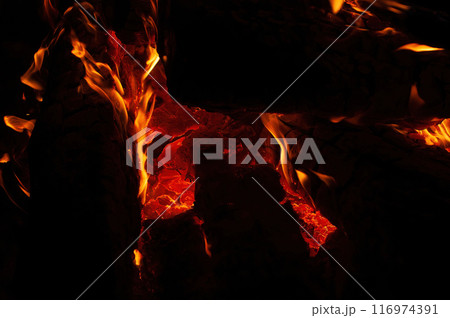 Close up of a bonfire blazing with intense heat against a 116974391