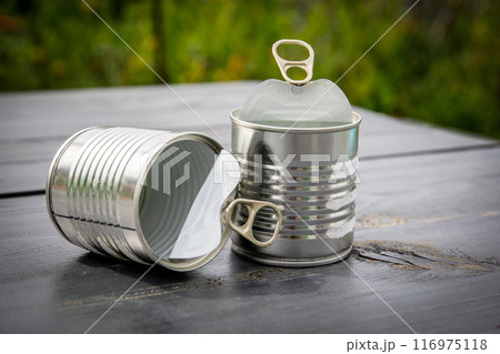 Twp empty and opened cans on wooden table Twp empty and opened cans on wooden table 116975118
