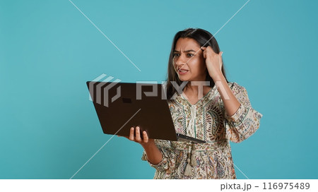 Irked woman fighting with coworkers during videocall on laptop, isolated over studio background. Outraged person arguing with colleagues during conversation on notebook, camera A Irked woman fighting with coworkers during videocall on laptop, isolated over studio background. Outraged person arguing with colleagues during conversation on notebook, camera A 116975489
