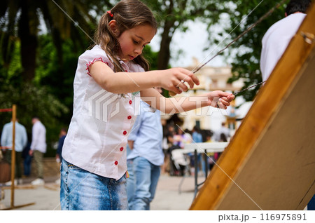 Young girl participating in outdoor activity at a park on a sunny day Young girl participating in outdoor activity at a park on a sunny day 116975891